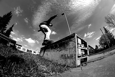 grayscale low angle of man in skateboard on concrete panel thumbnail