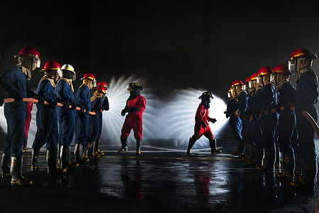 men in blue and red overalls forming two lines thumbnail