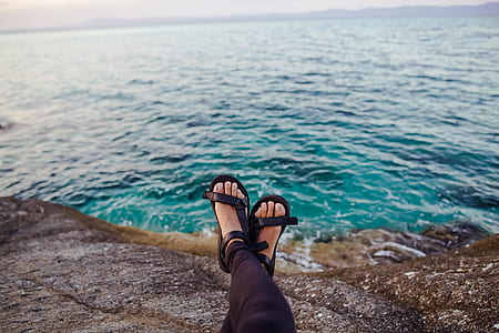 person wearing pair of black sandals thumbnail
