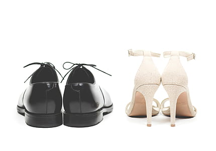 pair of black leather dress shoes beside pair of white ankle-strap pumps thumbnail