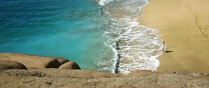 person standing on beach shore thumbnail