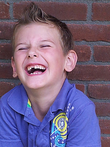 laughing boy while leaning on wall thumbnail