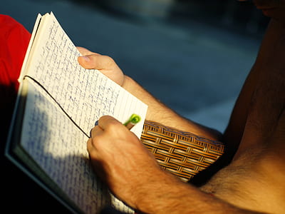 person writing on black line notebook thumbnail