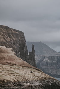 brown rocky mountain under dim cloudy sky thumbnail