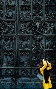 woman wearing yellow long-sleeved dress standing next to concrete wall during daytime thumbnail