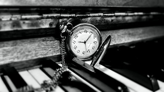 round white and silver-colored pocket watch on top of piano thumbnail