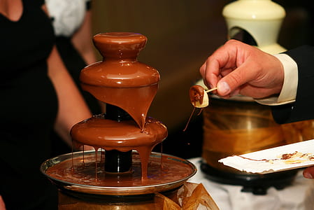 person standing in front of chocolate fountain thumbnail