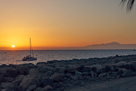 gray boat on body of water during golden hour thumbnail