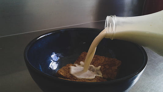 Milk Being Poured in Blue Ceramic Bowl With Cookies thumbnail