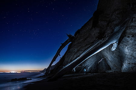 cliff near body of water during night time thumbnail
