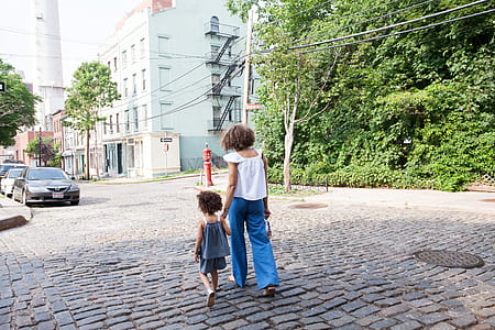 woman in white top holding a child thumbnail