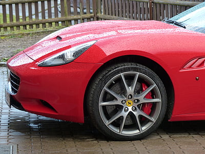 red Ferrari vehicle parked near wooden fence at daytime thumbnail