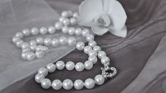 beaded white pearl necklace beside flower thumbnail
