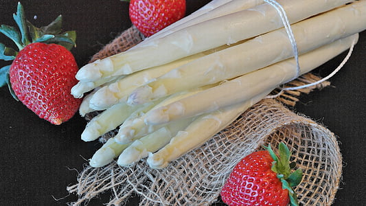 red strawberries and bamboo sprouts on black surface thumbnail