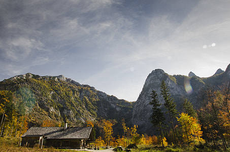gray house near trees and mountain under gray sky thumbnail