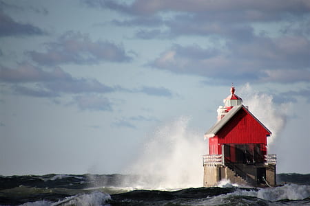 red and white lighthouse on body of water during daytime thumbnail
