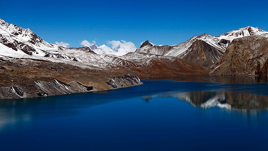 brown mountain with snow and body of water thumbnail