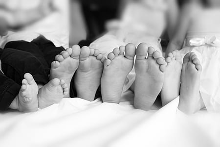 grayscale photography of four children's feet thumbnail