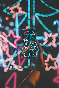 person taking blue and pink Christmas tree with string lights thumbnail