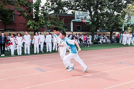 two men running on track field thumbnail