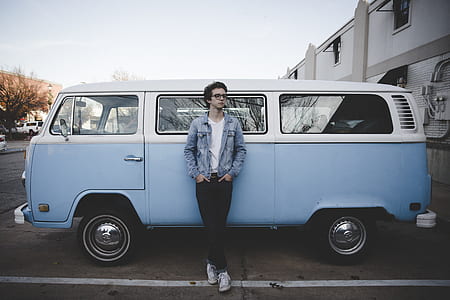 man leaning on white and blue Volkswagen T1 at daytime thumbnail