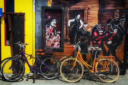 commuter bicycles parks beside yellow and brown wall houses thumbnail