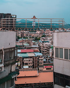 woman standing on building bridge near mountain range thumbnail