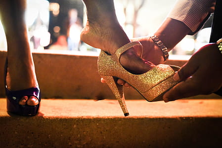 man holding gold-colored heeled sandal thumbnail