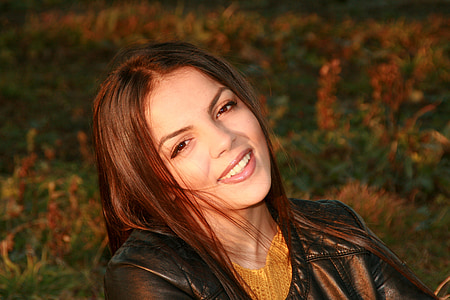 smiling woman in black leather jacket during day thumbnail