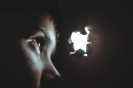 person peeping through hole thumbnail