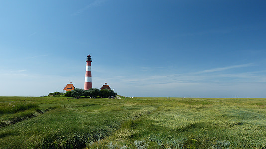 white and red lighthouse under blue sky during daytime thumbnail