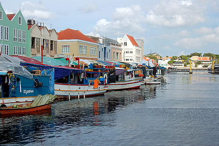 four assorted-color of boats on body of water thumbnail