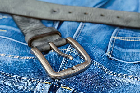 black leather belt with stainless steel buckle on top of blue textile thumbnail