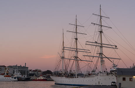 white ship near white wooden house thumbnail