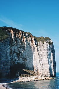 gray and green cliff near body of fwater thumbnail