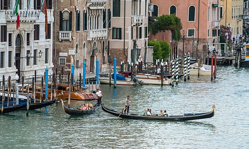people on boat on body of water near buildings during daytime thumbnail