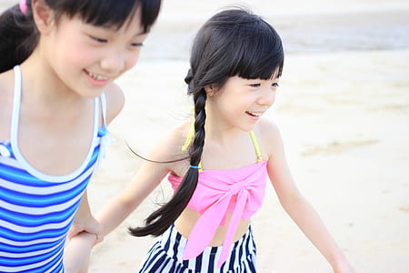 girl's in blue and pink spaghetti strap tops holding hands thumbnail