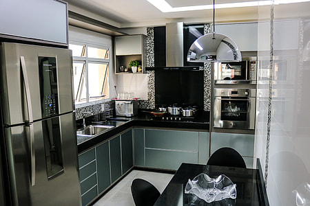 kitchen cupboard and island beside stainless steel refrigerator thumbnail