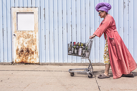 man in pink bathrobe pushing cart outdoors at daytime thumbnail