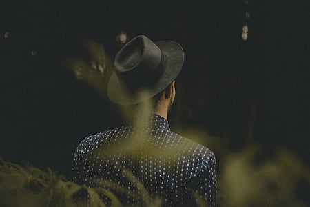 man wearing gray hat and blue collared top standing near grass thumbnail