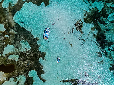 aerial photography of blue boat on river at day time thumbnail
