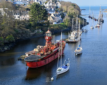 white and red boats sailing near concrete buildings at daytime thumbnail