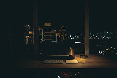 flat screen monitor, wireless keyboard, and touch pad on wooden surface near window thumbnail