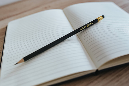Notebooks with colourful pencils on a wooden desk thumbnail