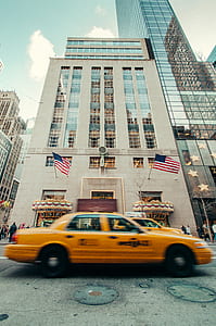 yellow taxi cab in front of building thumbnail