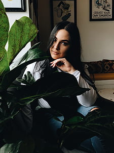 woman sitting on chair beside the leafed plant thumbnail