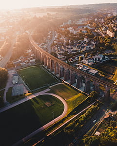 aerial photo of brown concrete train trail near buildings during golden hour thumbnail