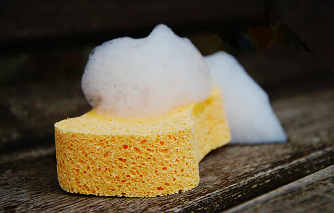 yellow sponge with bubbles on brown wooden surface thumbnail