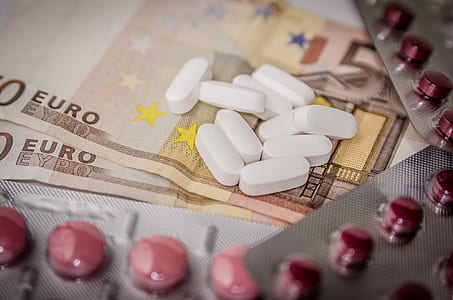 oblong white medication tablet on banknote thumbnail