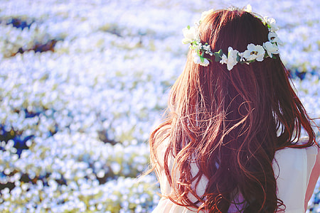 woman wearing white flower wreath beside blooming white flower field during daytime thumbnail
